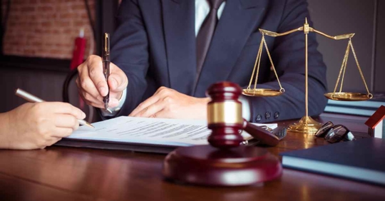 An attorney sitting at a desk filling out some paperwork