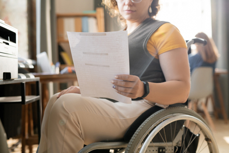 woman in a wheelchair reading a document